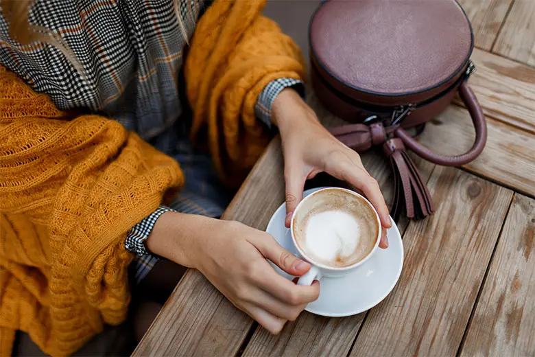woman-drinking-coffee-stylish-bag-table-wearing-grey-dress-orange-plaid-enjoying-cozy-morning-cafe